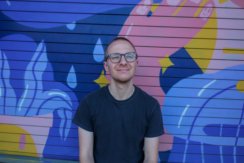 a man standing in front of a colorful wall