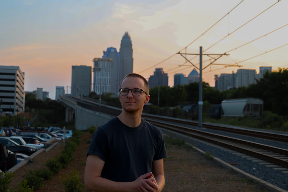 a man standing in front of a train track