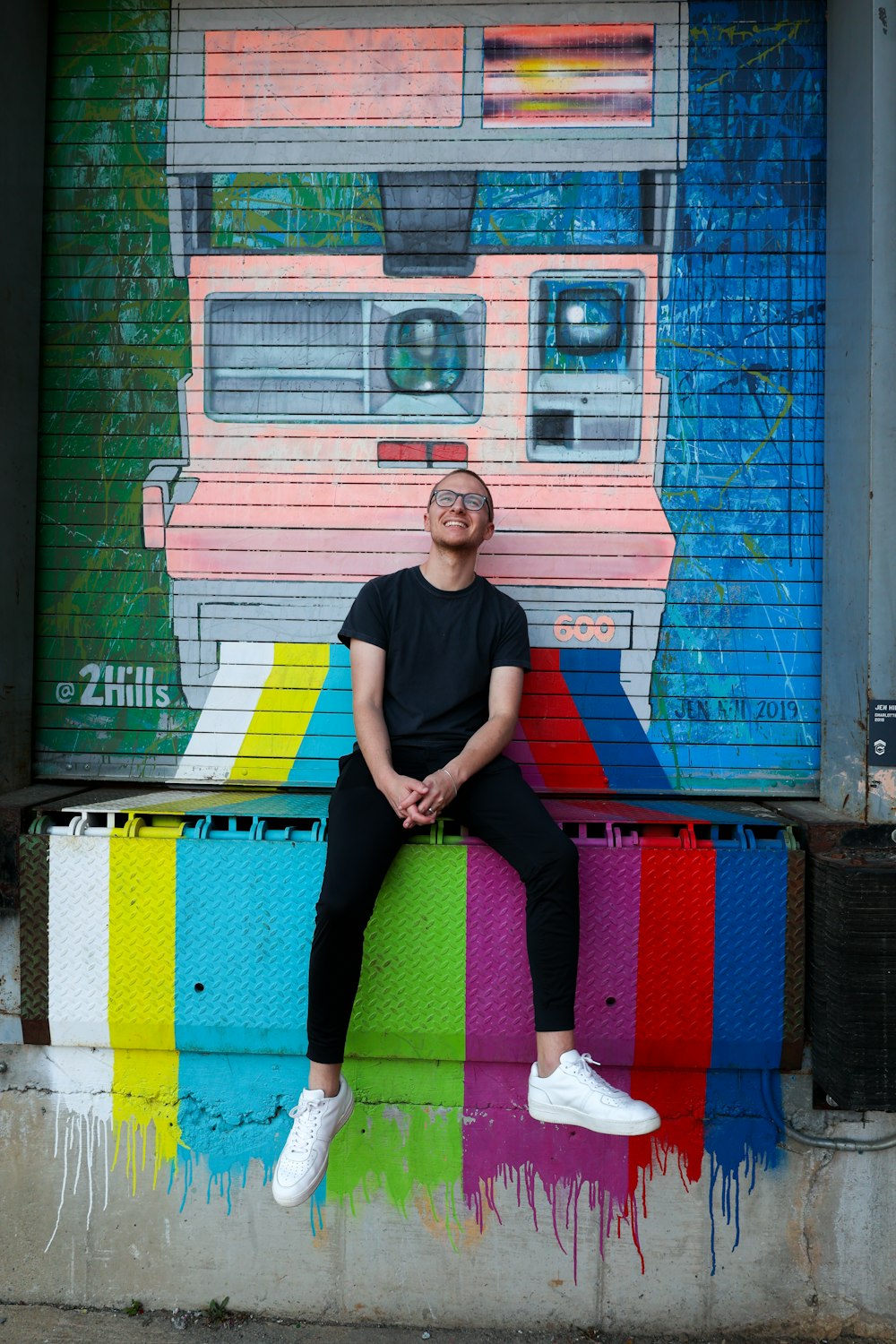 a man sitting on top of a colorful bench