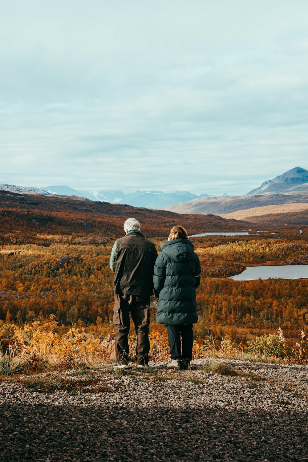 a couple of people standing on top of a hill