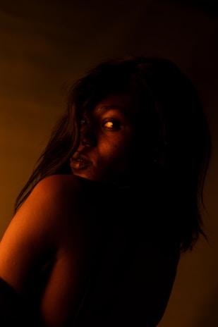 A cinematic still from a moody music video featuring dramatic lighting and gold accents.