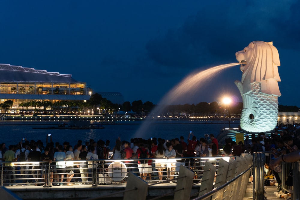 a crowd of people standing around a large statue