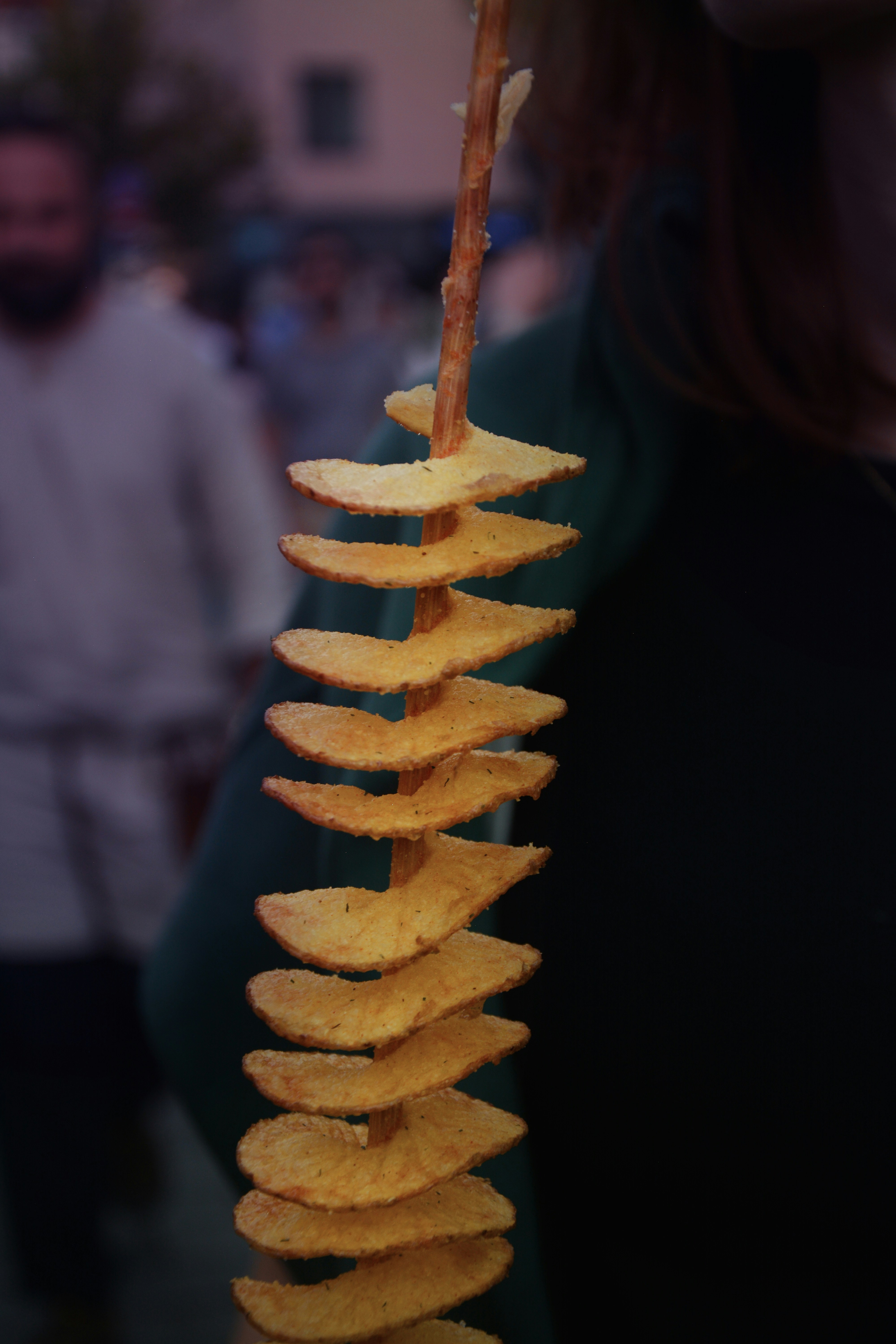 a person holding a stick of potato chips