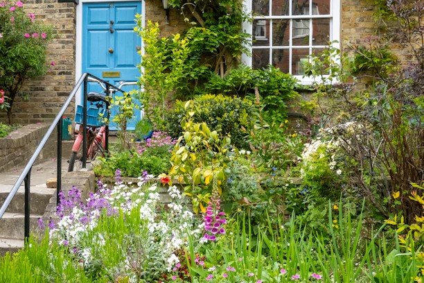 Cozy home entrance with a well-kept garden and bright flowers.