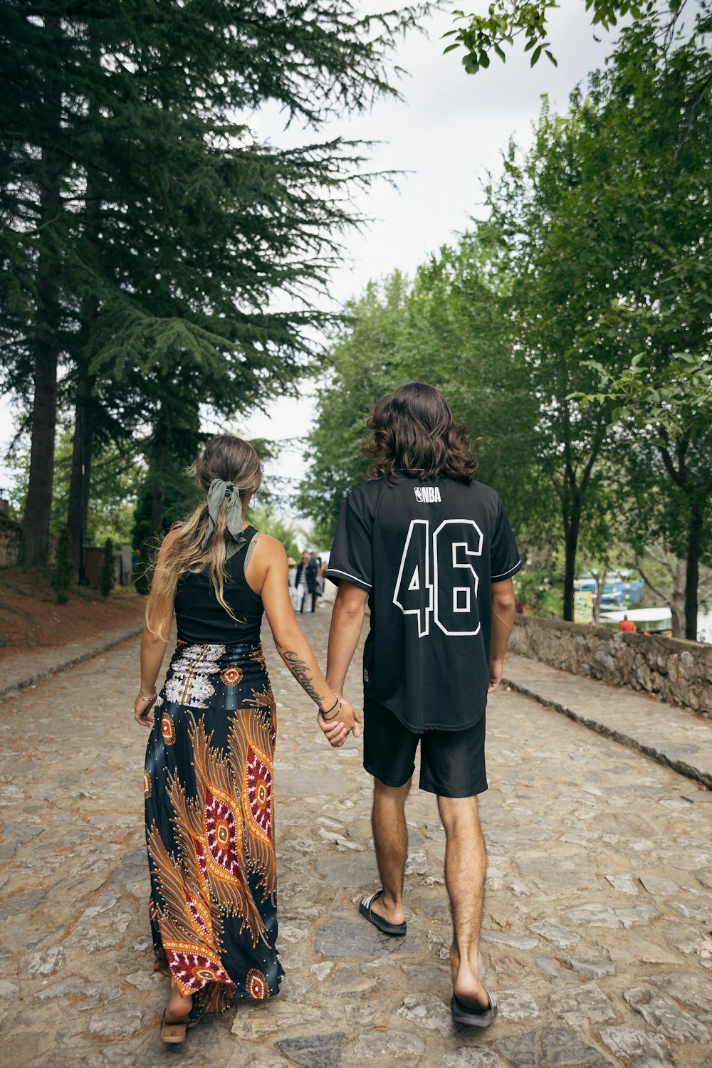 a man and a woman walking down a street holding hands