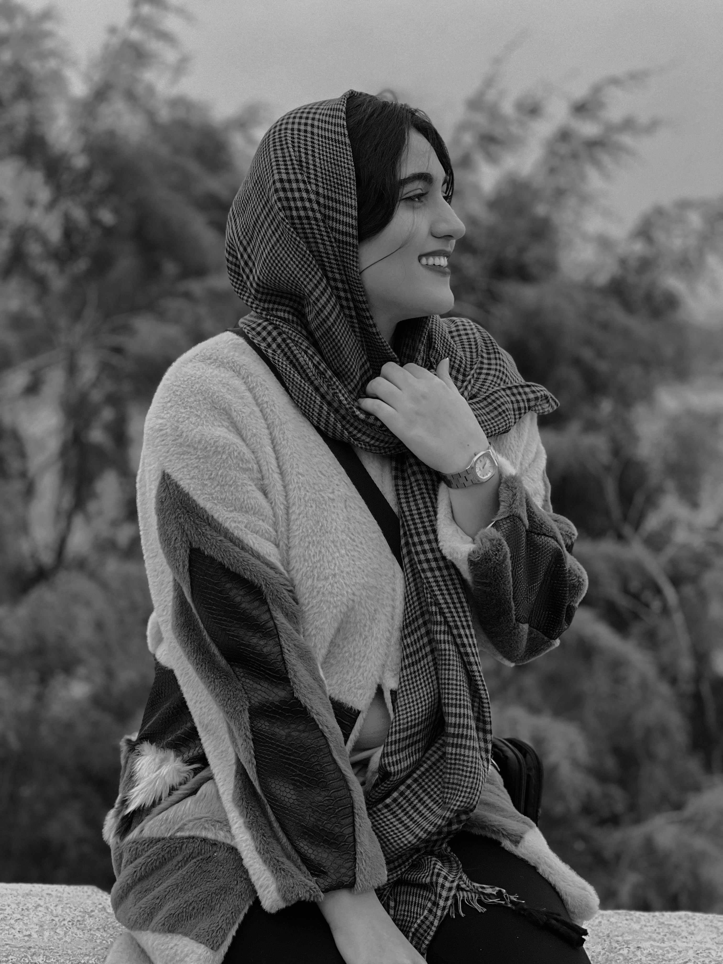 seorang wanita duduk di langkan dengan syal di sekitar kepalanya