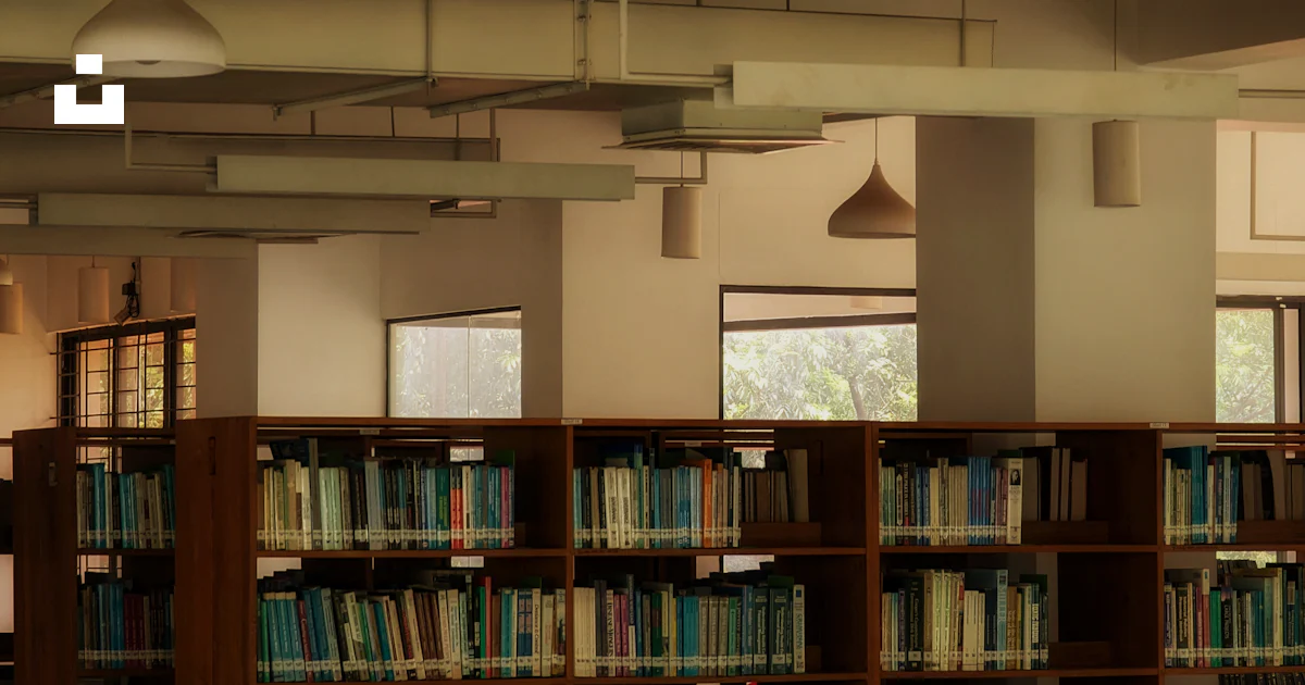 Library Building Bd A library filled with lots of books and lots of green chairs photo ...