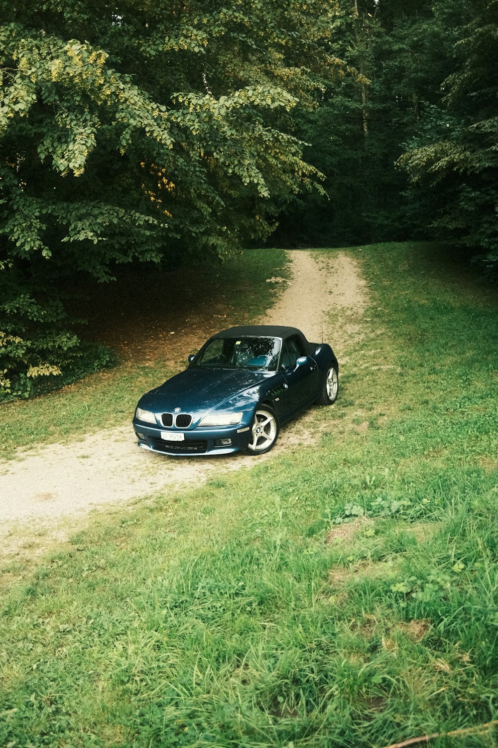 a car is parked on a dirt road