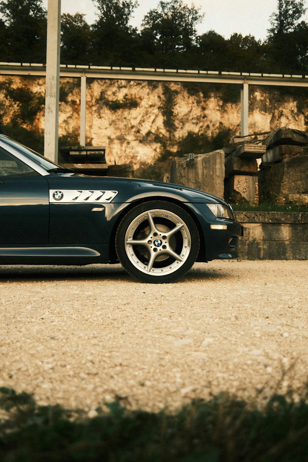 a black sports car parked in front of a stone wall