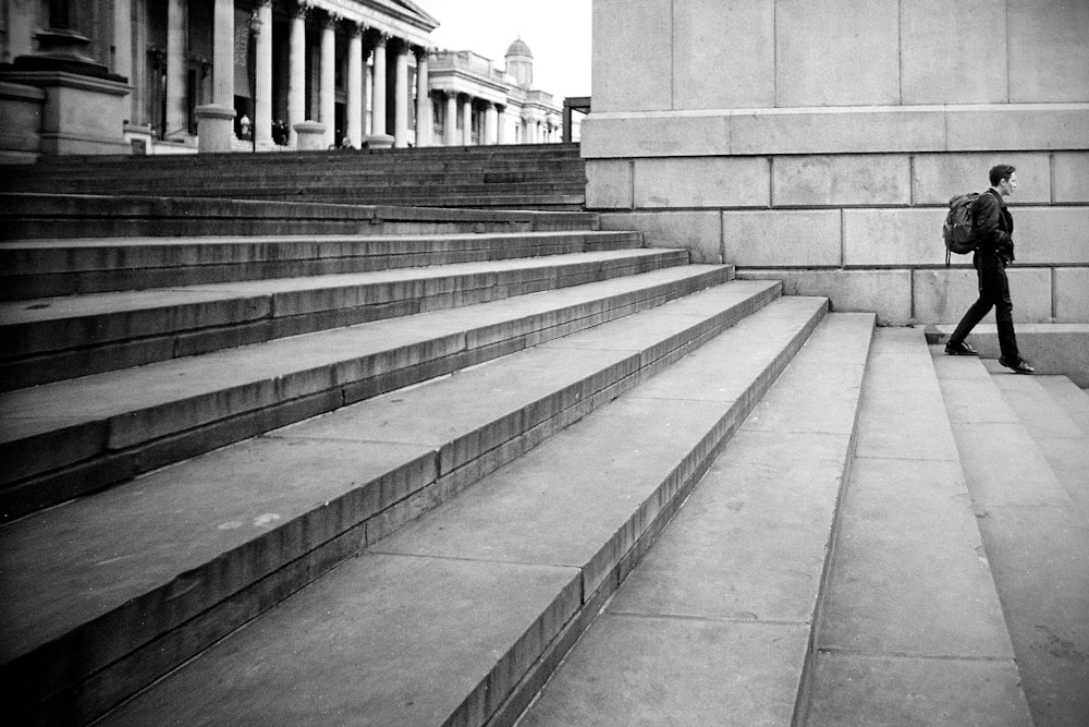 a man walking up some steps with a backpack