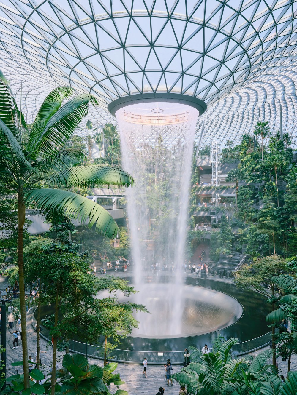 a large waterfall in the middle of a tropical garden