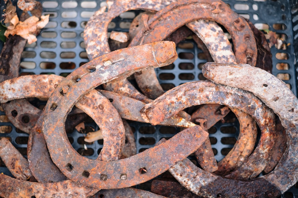 a pile of rusted metal rings sitting on top of a metal grate