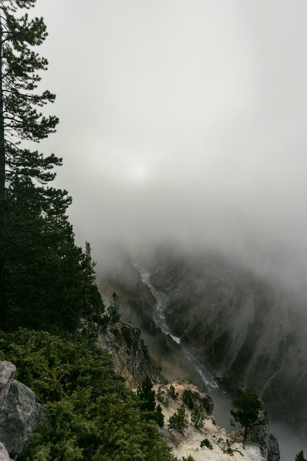a foggy mountain with a river running through it