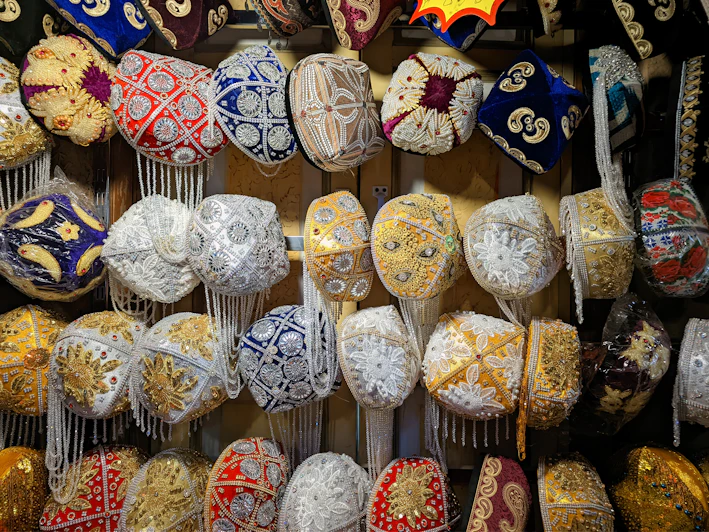 A colorful collection of personalized embroidered hats displayed on a rustic wooden table.