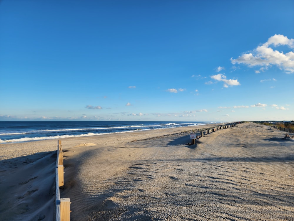 uma praia de areia ao lado do oceano sob um céu azul