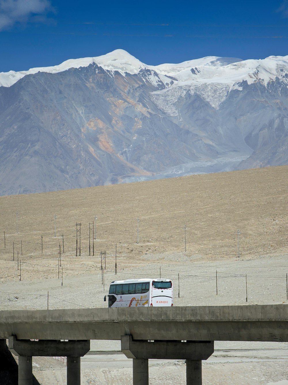 a bus driving on a highway with mountains in the background