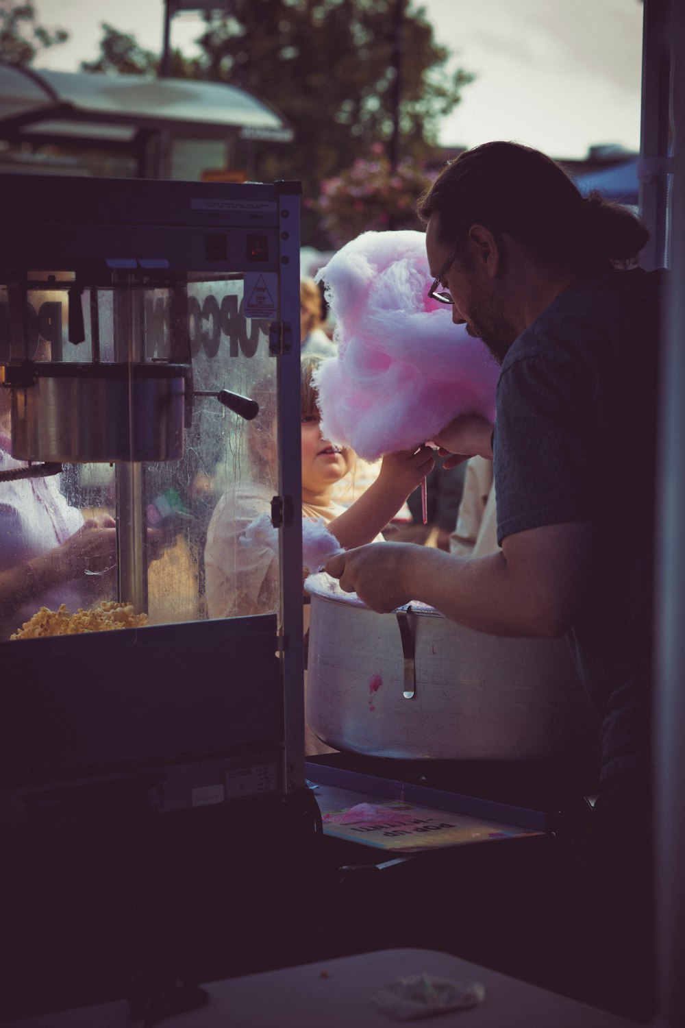 a man holding a pink stuffed animal in front of a machine