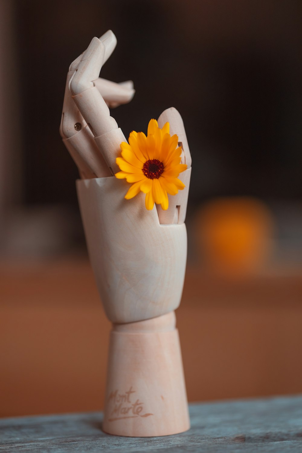 a ceramic sculpture of a hand holding a sunflower