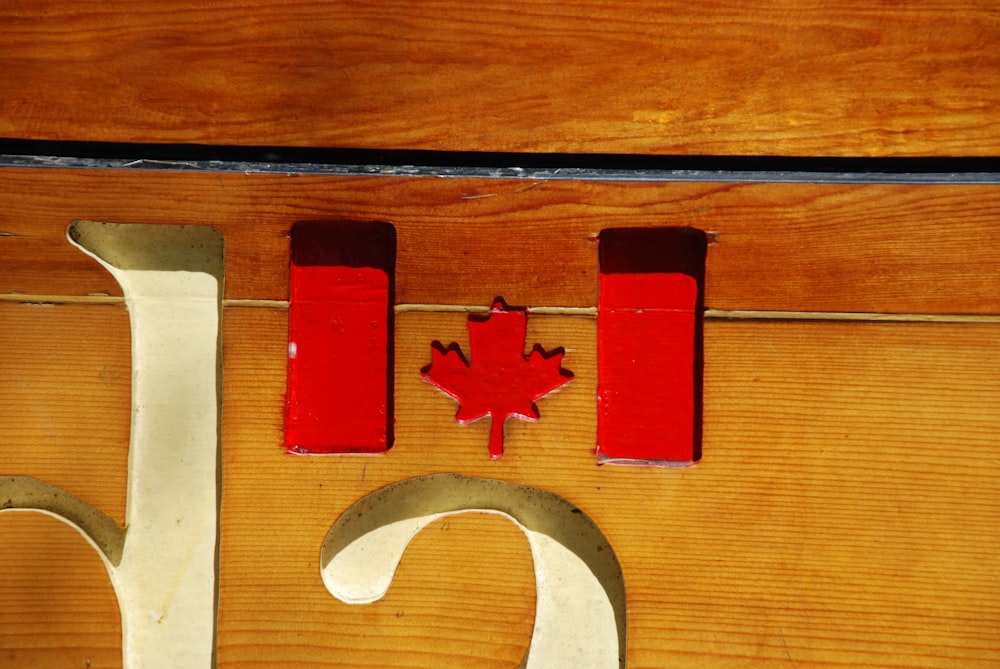 a close up of a wooden sign with a canadian flag on it