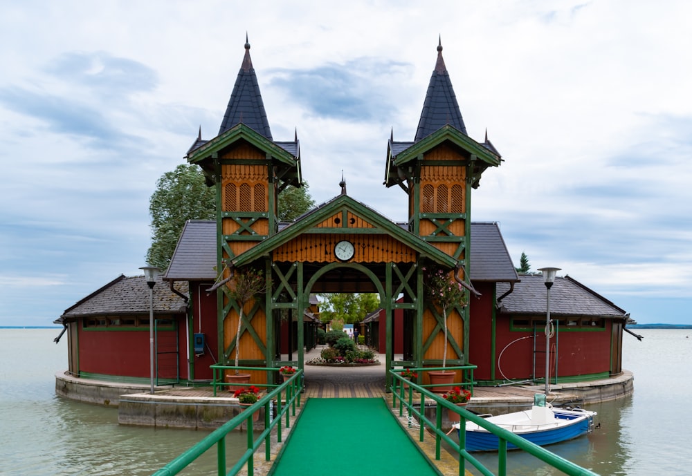 a boat dock with a green walkway leading to a red building