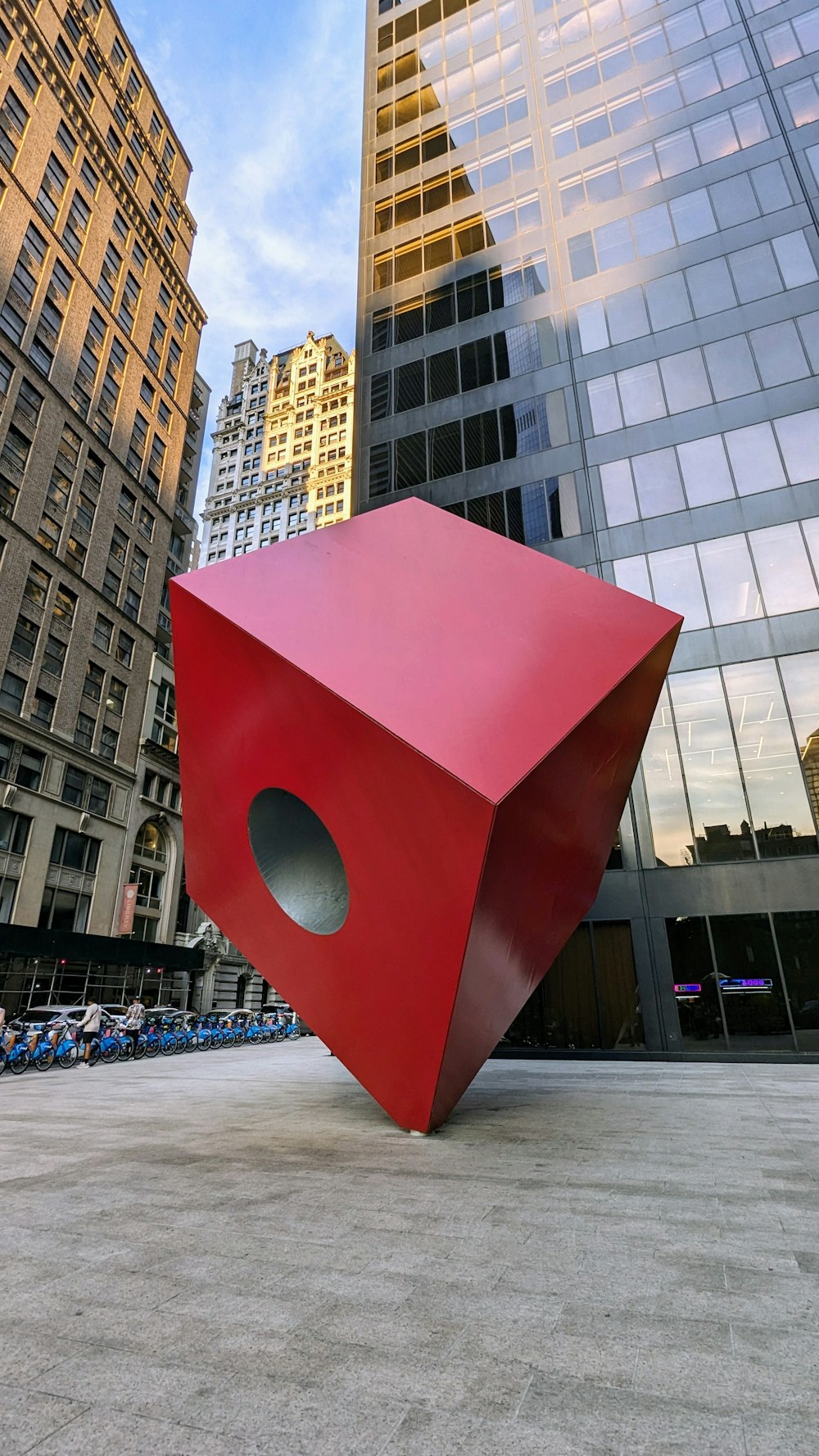 a large red object sitting in front of tall buildings