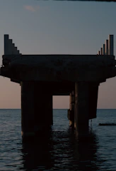 Finished pier extending over calm water at sunset, highlighting craftsmanship.