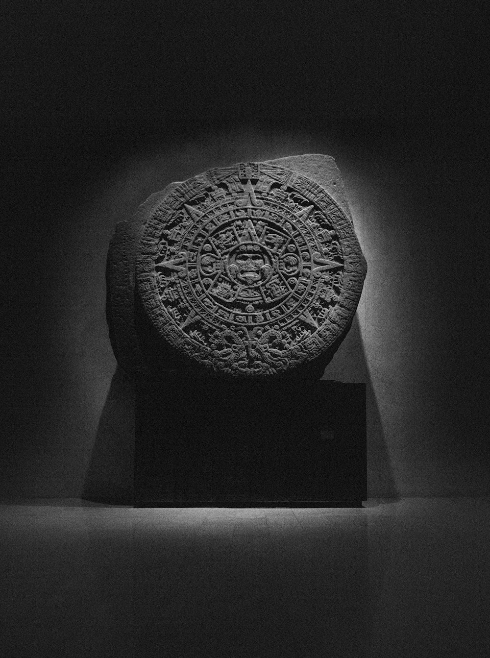 a black and white photo of a stone in a dark room