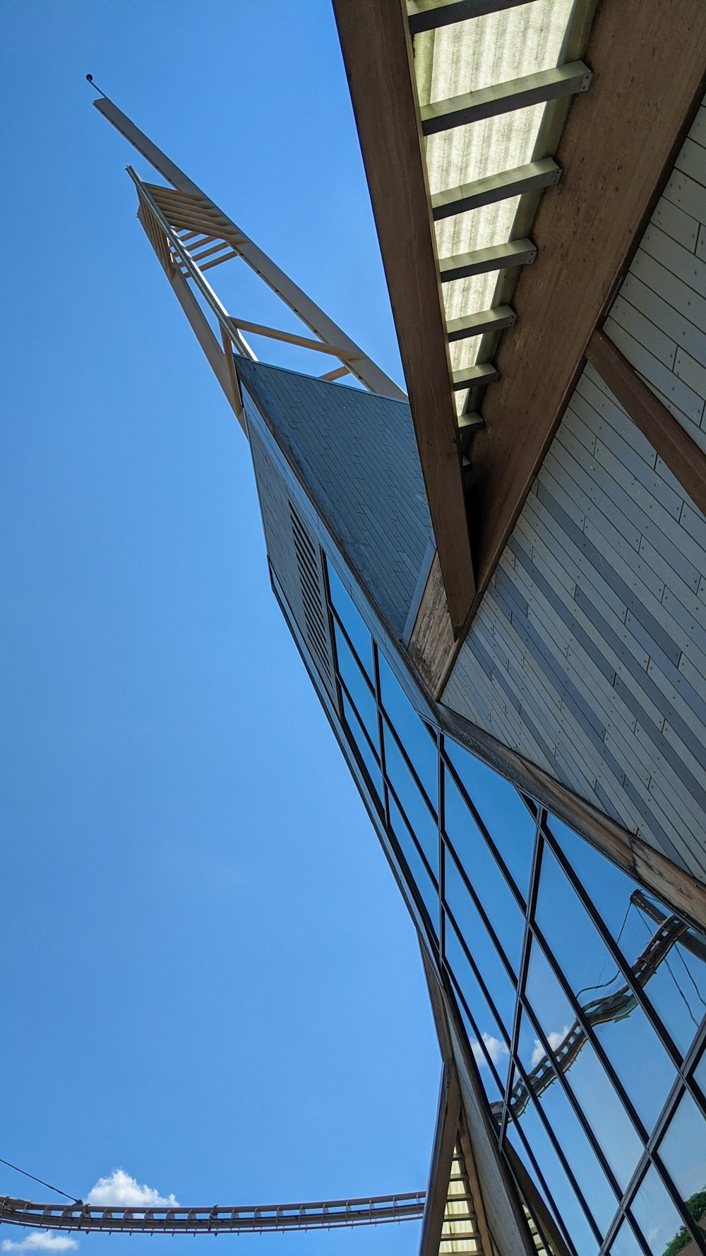 looking up at the roof of a building with a bridge in the background