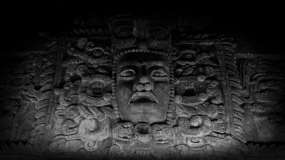 a black and white photo of a face on a wall