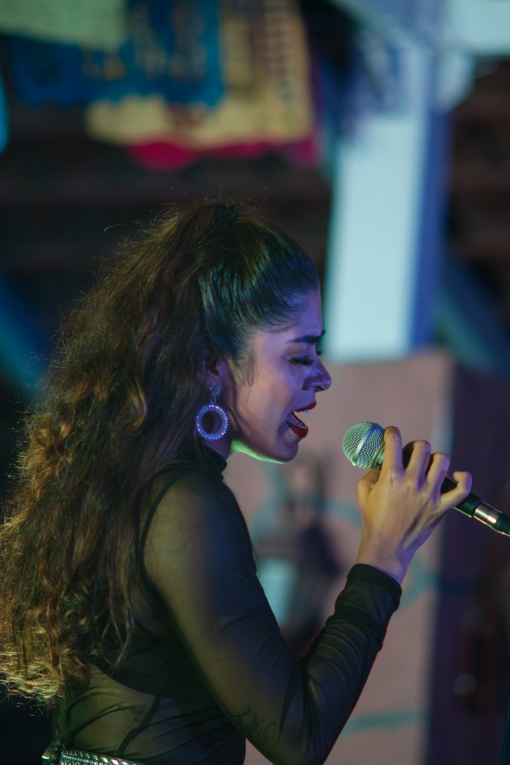 a woman singing into a microphone in front of a microphone