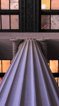 An elegant marble column entwined with glowing soundwave patterns under soft golden light.