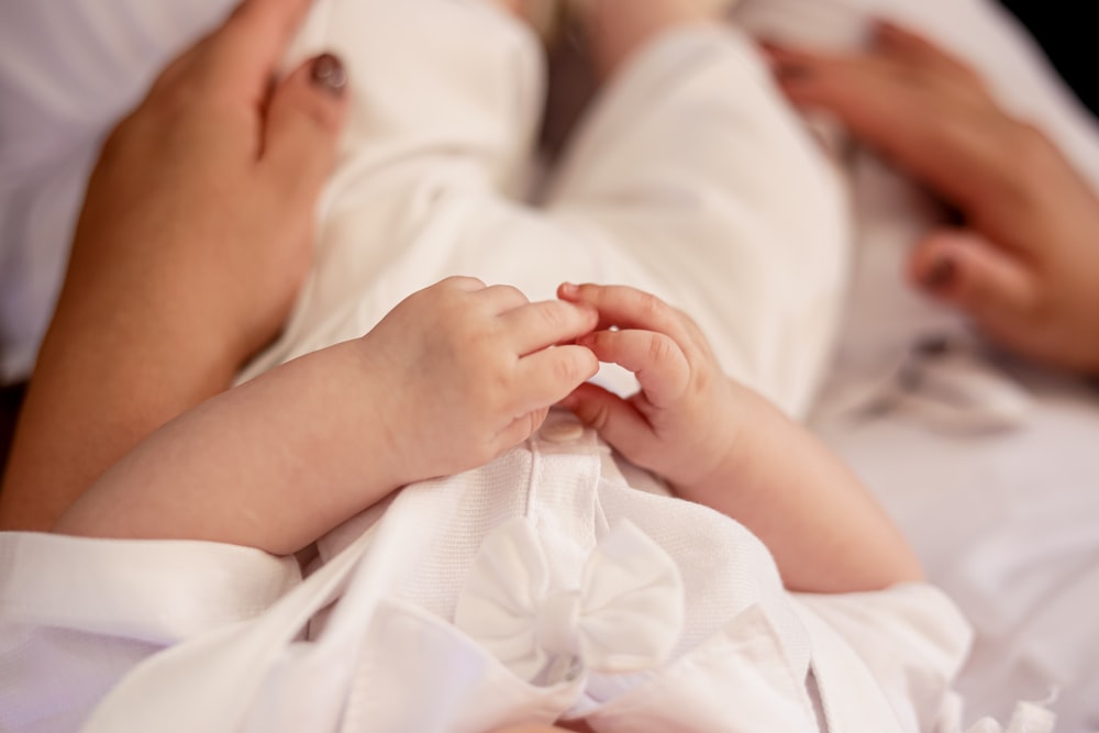 a close up of a person holding a baby