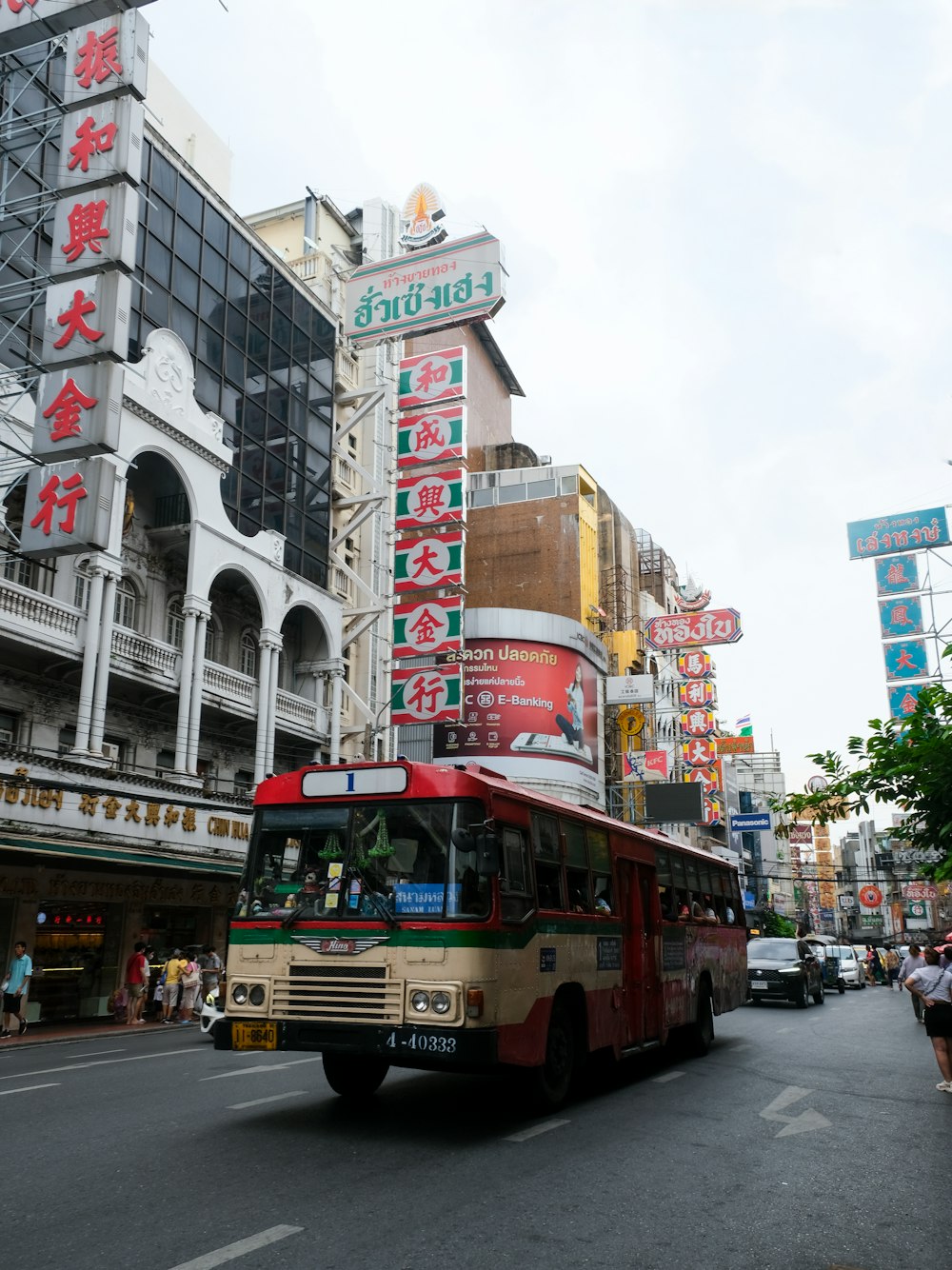 a bus driving down a street next to tall buildings