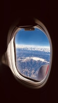 A private jet soaring above stunning mountain ranges.