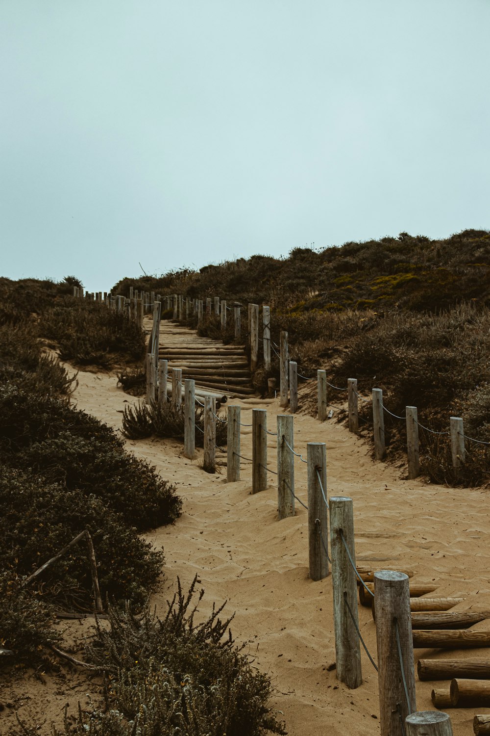 a sandy path leading to a sandy beach