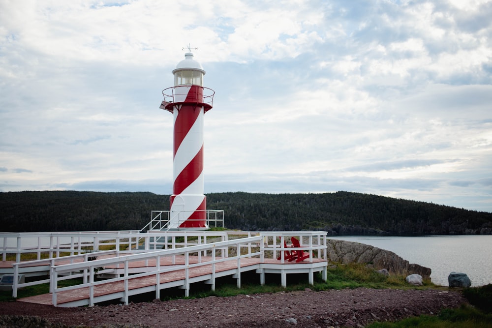 a red and white lighthouse sitting on top of a pier