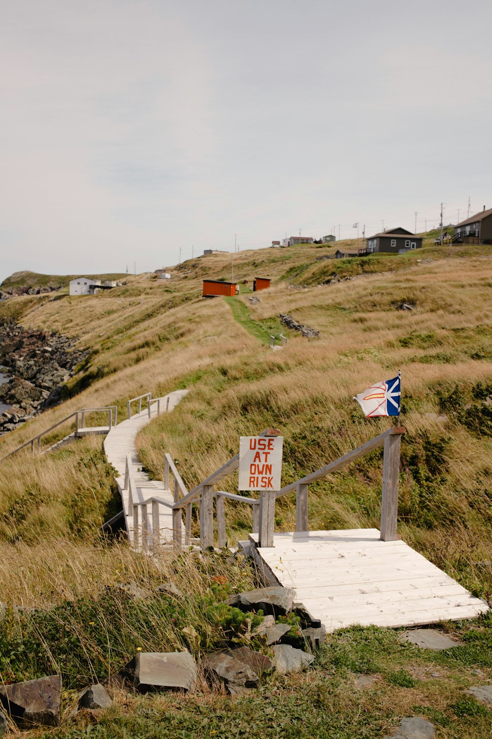 a wooden ramp leading to a sign on a hill
