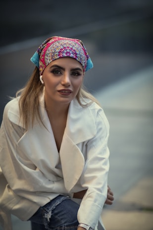 A close-up of a person wearing a fashionable scarf and statement earrings in a bright setting.