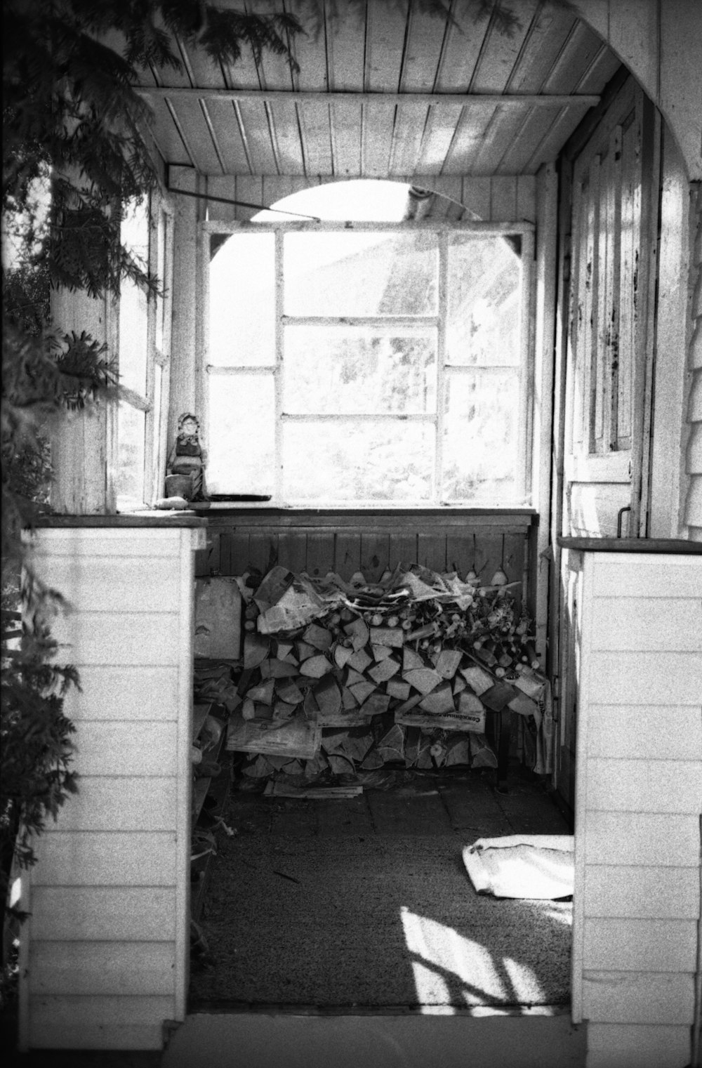 a black and white photo of a room with a bunch of firewood