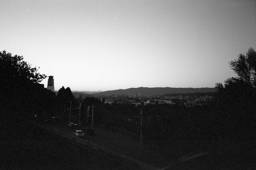 a black and white photo of a city at dusk