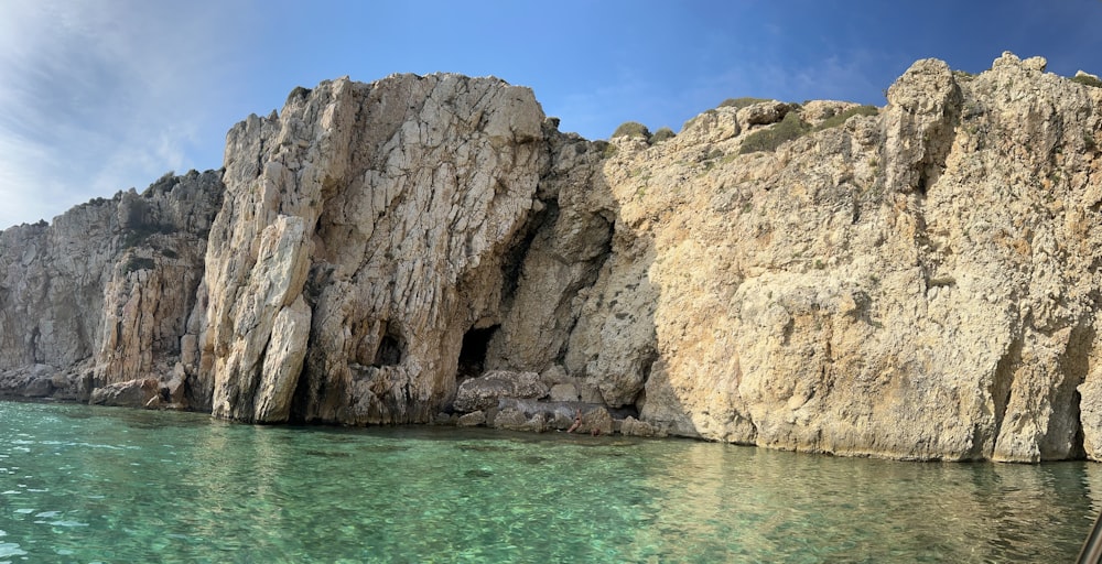 a large rock formation next to a body of water