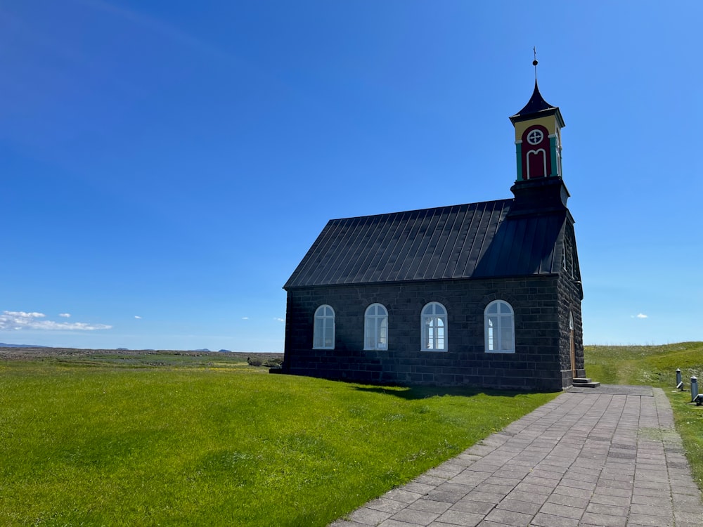 a small black church with a clock tower