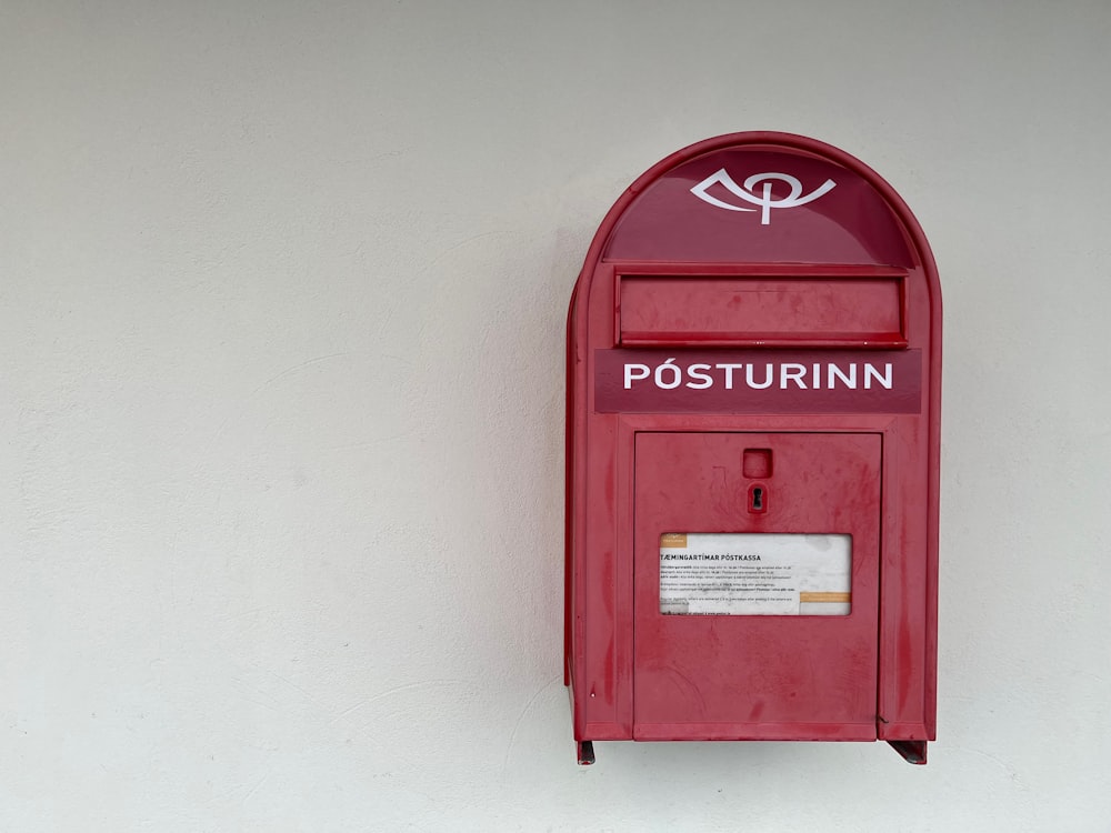 a red mailbox mounted to the side of a wall