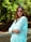 a woman with glasses standing in a park