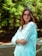 a woman with glasses standing in a park