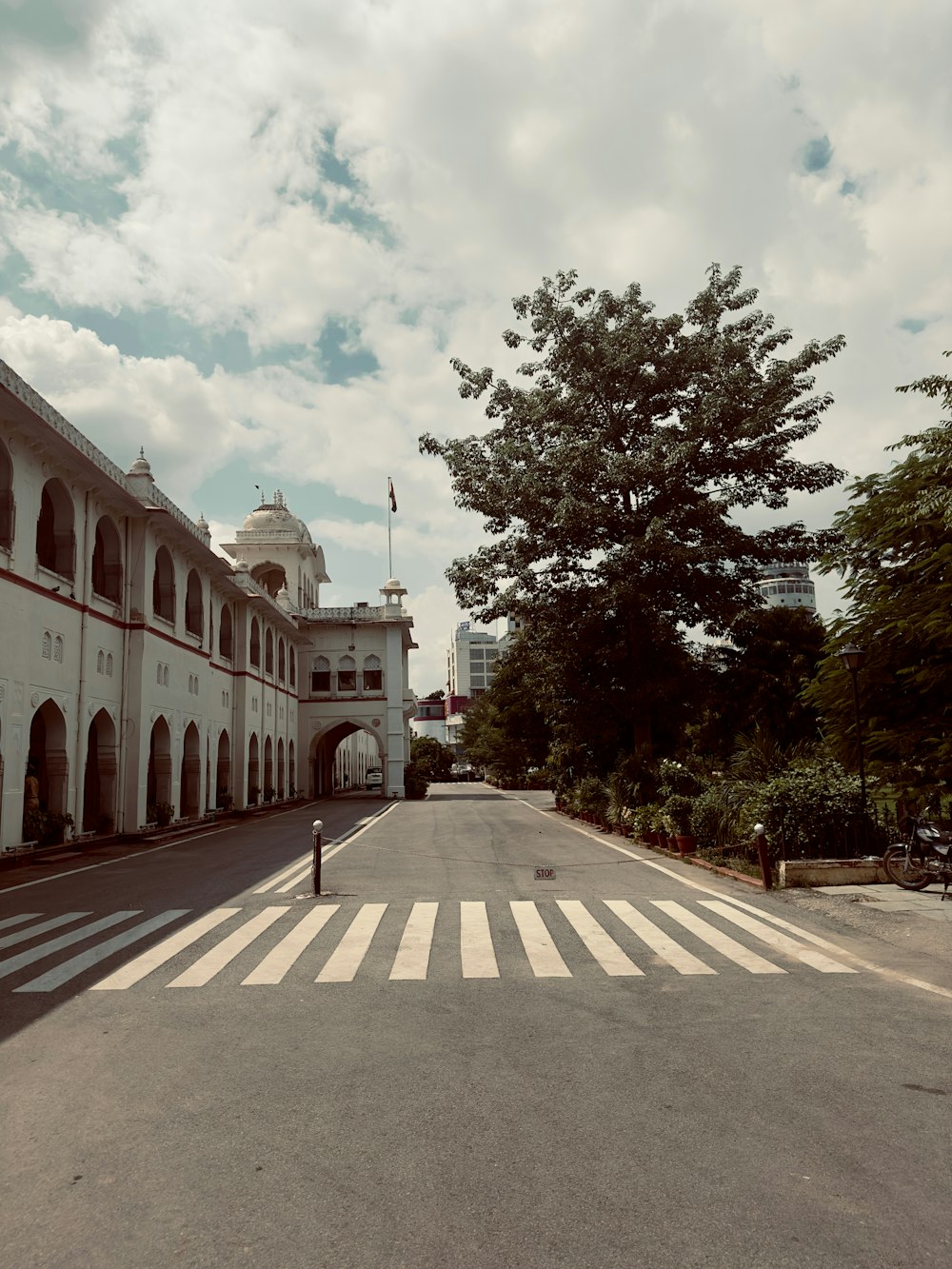 an empty street with a large building in the background