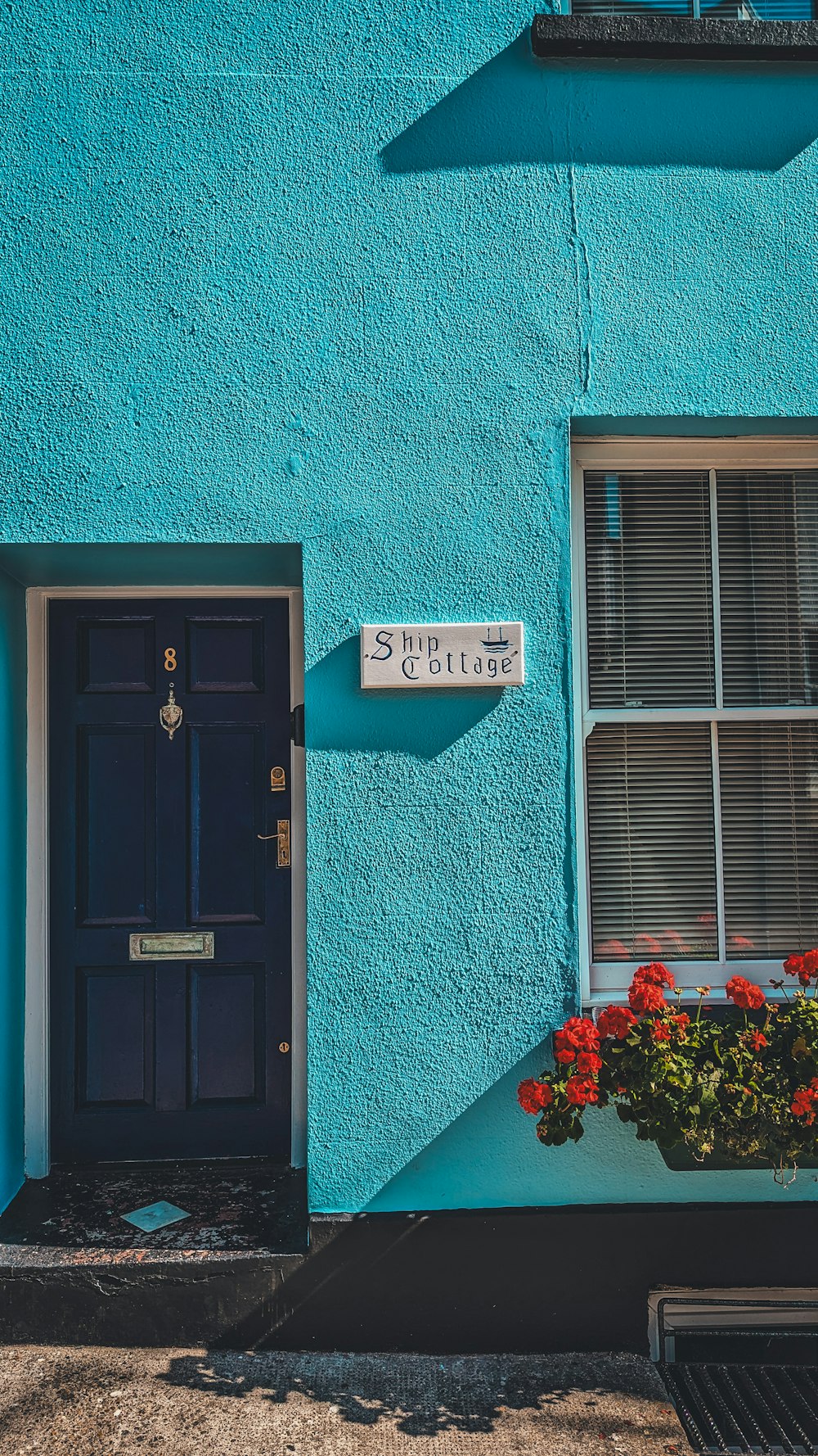 a blue building with a black door and window