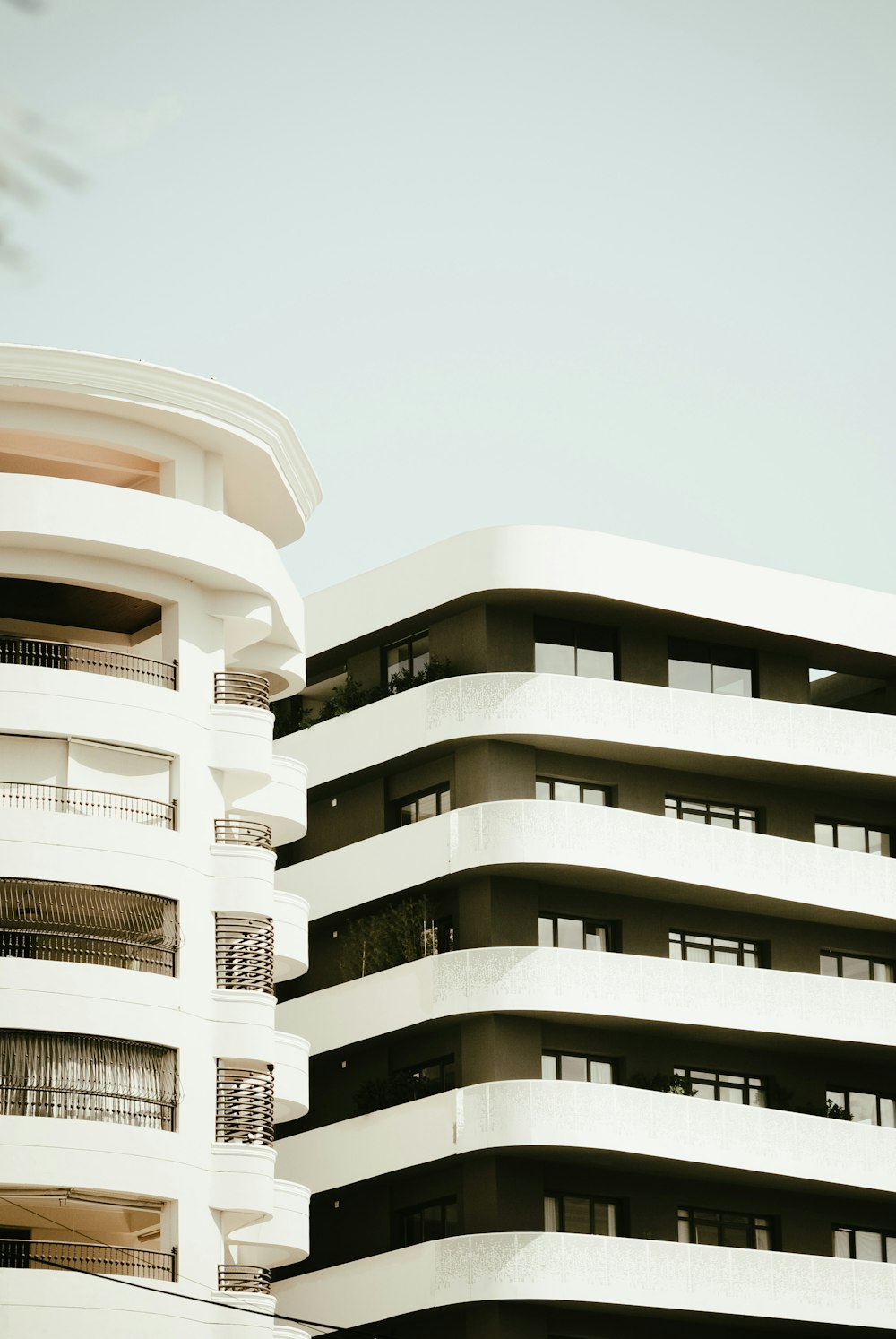 a tall white building with balconies on top of it