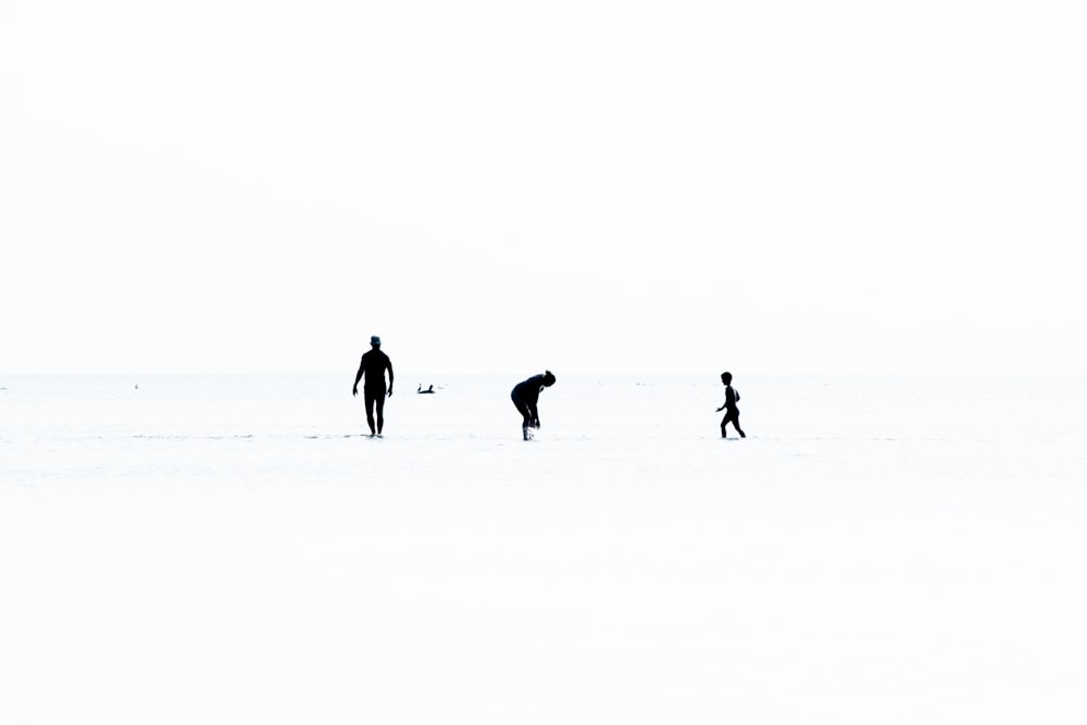 a group of people walking across a snow covered field