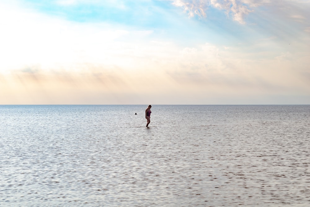 a person standing on a surfboard in the middle of the ocean